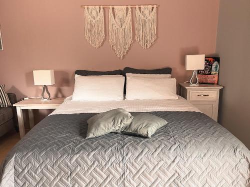 um quarto com uma cama com duas almofadas em The Blue Door Apartment em Cahersiveen