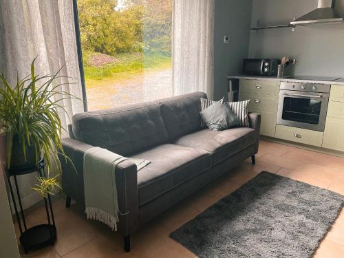 a living room with a couch in front of a window at The Blue Door Apartment in Cahersiveen
