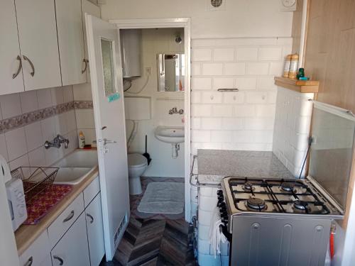 a small kitchen with a stove and a sink at Zacisze in Supraśl