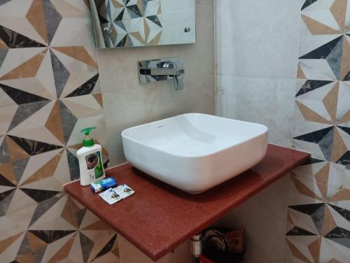 a white sink on a counter in a bathroom at VRINDA Kunj ASHRAYAM in Vrindāvan