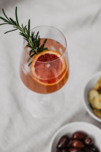 a drink in a glass on a table with a plate of food at Bootshaus Amberg in Amberg