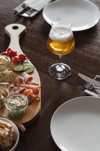 a wooden table with a glass of beer and food at Bootshaus Amberg in Amberg