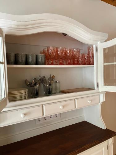 a kitchen cabinet with dishes and utensils in it at Emakaru Puhkemaja in Otepää