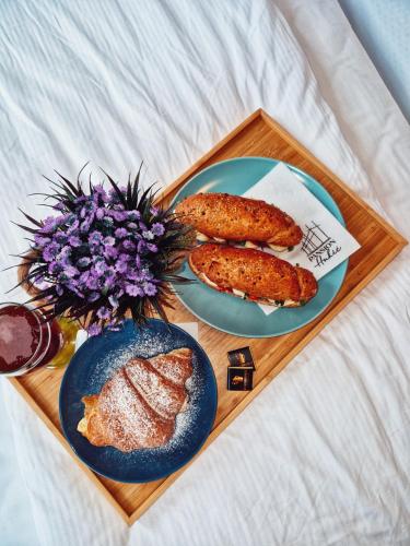 a tray with two plates of food on a bed at Pansion Hukić B&B in Tuzla