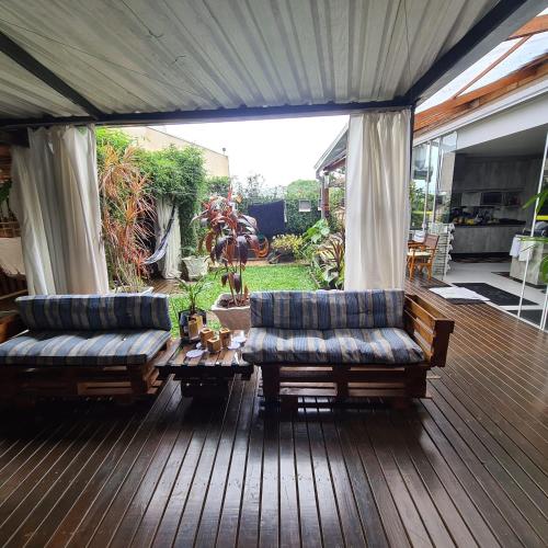 a porch with two couches on a wooden deck at Hostel AJBJ Turismo in Curitiba