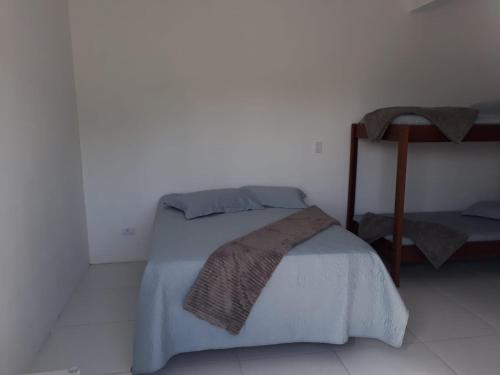 - une chambre blanche avec un lit dans l'établissement Recanto da Preguiça - Suites, à Pontal do Paraná