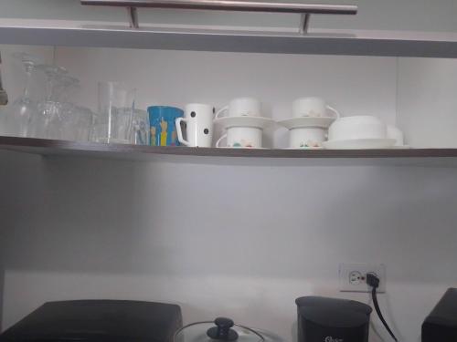 a shelf with cups and other items on it at Apartamento en BalaBeach María Chiquita in front of the beach 2hab in Colón