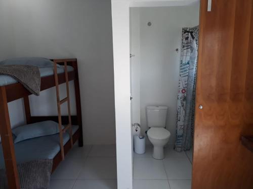 two bunk beds in a room with a toilet at Recanto da Preguiça - Suites in Pontal do Paraná