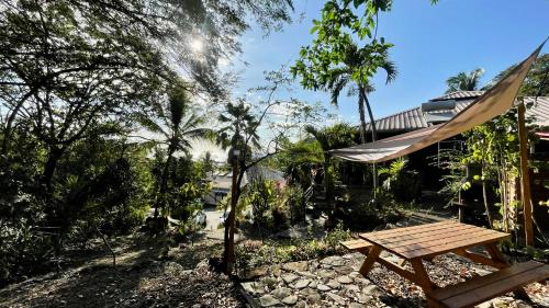 a picnic table and a hammock in a garden at Location gîte bungalow à 70m de la plage in Bouillante