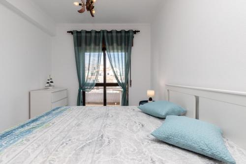 - une chambre avec un grand lit et une fenêtre dans l'établissement Apartamento MANTAMAR by ALGARVEMANTA, à Manta Rota