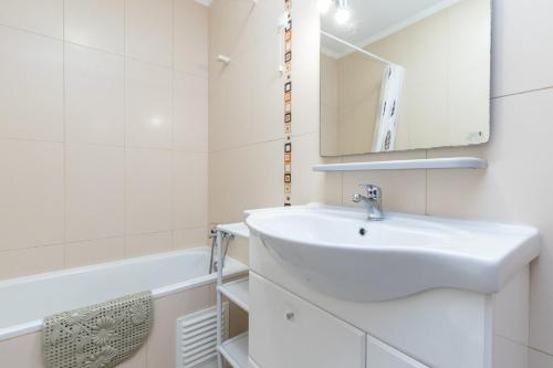 La salle de bains est pourvue d'un lavabo, d'un miroir et d'une baignoire. dans l'établissement Apartamento MANTAMAR by ALGARVEMANTA, à Manta Rota