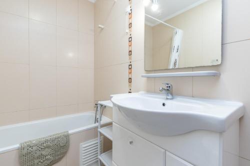 Un baño con lavabo, espejo y bañera. en Apartamento MANTAMAR by ALGARVEMANTA, en Manta Rota