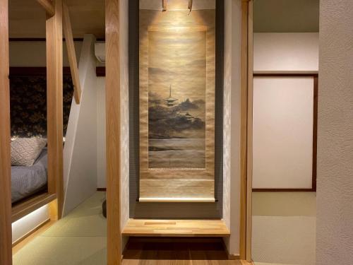 un miroir dans une pièce avec un tableau sur le mur dans l'établissement 京都 三日月 Mikazuki, à Kyoto