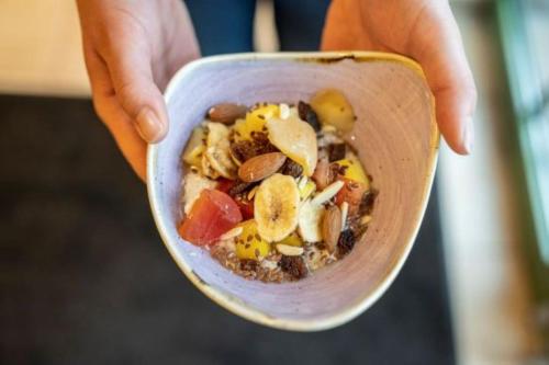 a person holding a wooden bowl filled with food at Posthotel Radstadt in Radstadt