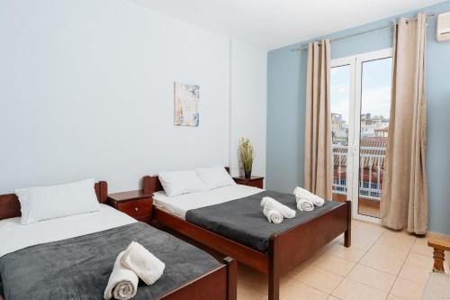 a bedroom with two beds and a balcony at Villa Estelle in Paralia Katerinis