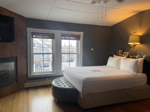 um quarto com uma cama grande e uma lareira em Somerset House Inn em Provincetown