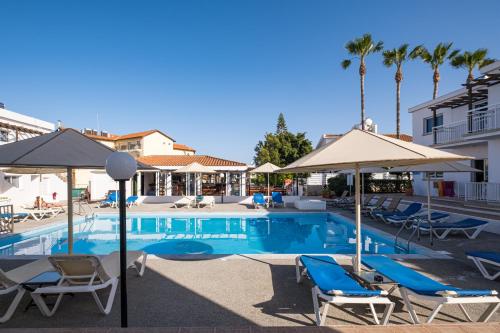 a swimming pool with chairs and umbrellas at Anais Bay Hotel in Protaras