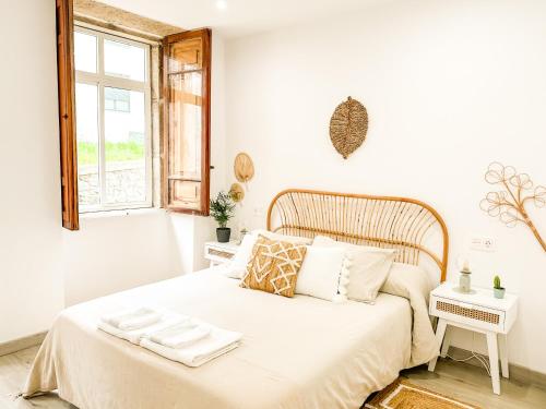 1 dormitorio con 1 cama con sábanas blancas y ventana en A Lobeira Grande by ALÔGA, en Cee
