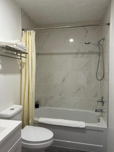 bagno bianco con vasca e servizi igienici di Motel le Sabre a Sherbrooke