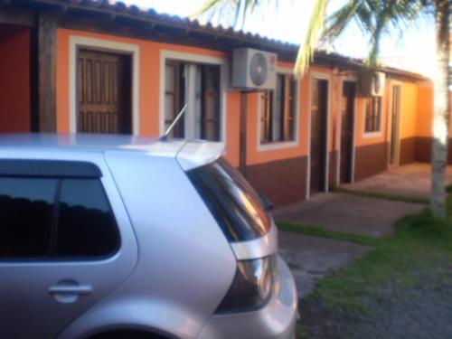 une voiture en argent garée devant une maison dans l'établissement Pousada Enseada do Coqueiro, à Guarapari