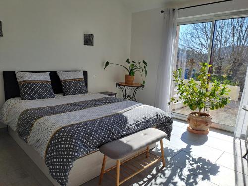 ein Schlafzimmer mit einem Bett und einem großen Fenster in der Unterkunft chambre d'hôtes chez Jessica et Pascal in Barjols