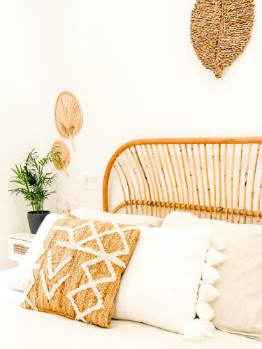 a bed with white pillows and a wooden headboard at A Lobeira Grande by ALÔGA in Cee