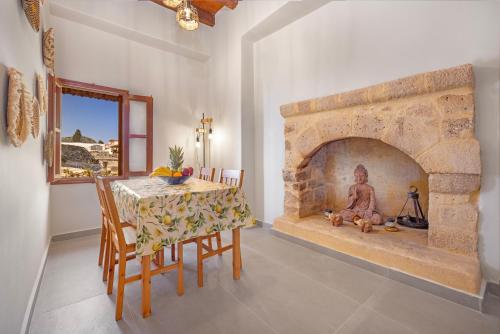 ein Esszimmer mit einem Tisch und einem Steinkamin in der Unterkunft Casa Della vita Loft ,Rhodes Old town in Rhodos (Stadt)