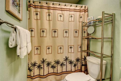 a bathroom with a shower curtain with palm trees at Bay Tree B5 in Port Aransas