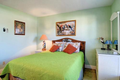 a bedroom with a green bed with orange pillows at Bay Tree B5 in Port Aransas
