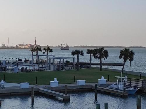 a marina with palm trees and a boat in the water at Bay Tree B5 in Port Aransas
