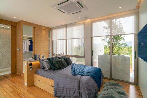 a bedroom with a bed and a large window at Luxury 3 Bedrooms Villa Bangtao in Ban Pa Khlok