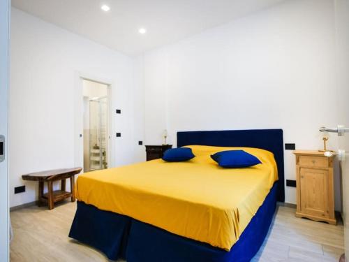 - une chambre avec un lit jaune et des oreillers bleus dans l'établissement Casa Anselmo, à Côme