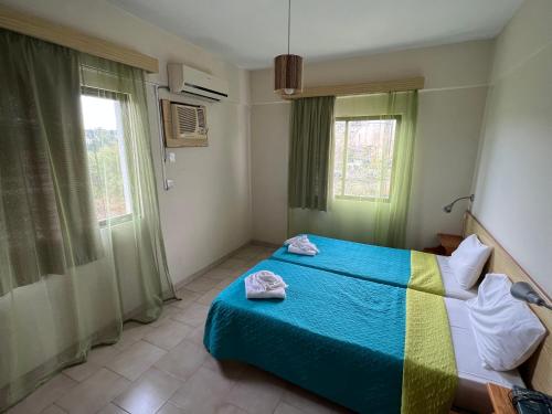 a bedroom with a bed with two towels on it at Maouris Hotel Apartments in Protaras
