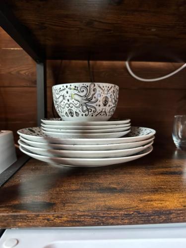 a stack of plates and a bowl on a table at Herigerbi Park Woodland cabin in Grantham