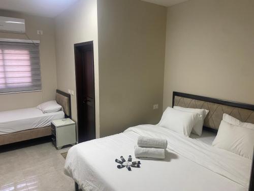 um quarto com duas camas com lençóis brancos e flores na cama em فندق وادي القلط em Jericó