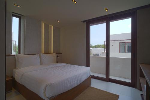 a bedroom with a bed and a large window at Araya Beach Casas in Batangas City