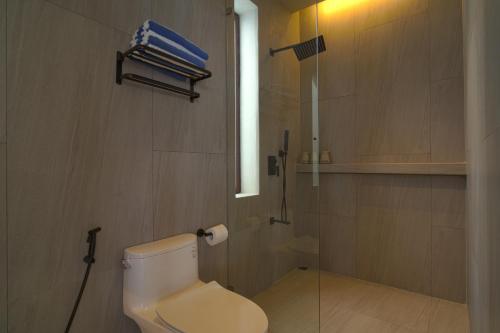 a bathroom with a white toilet and a window at Araya Beach Casas in Batangas City