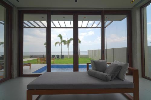 a room with a bed with a view of the ocean at Araya Beach Casas in Batangas City