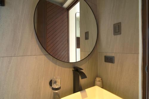 a bathroom with a mirror and a sink at Araya Beach Casas in Batangas City
