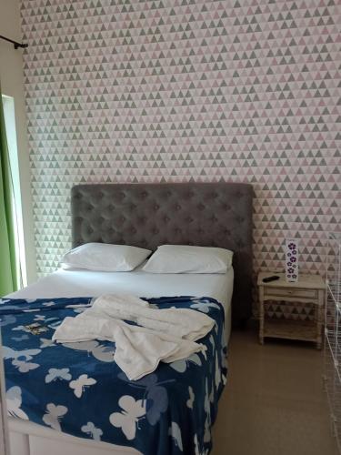 アハイアウ・ド・カボにあるMar & Mar Suitesのベッドルーム1室(青い掛け布団、白い枕付きのベッド1台付)