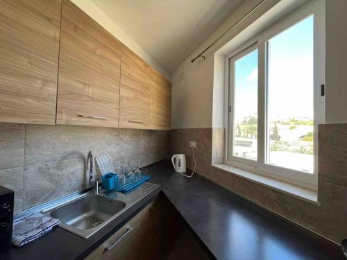 a kitchen with a sink and a window at Lovely 3 Bedroom Condo in St. Julianʼs