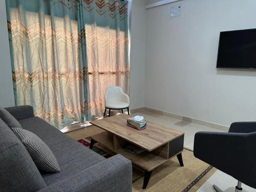 ein Wohnzimmer mit einem Sofa und einem Couchtisch in der Unterkunft Janneya Apartments in Sukuta