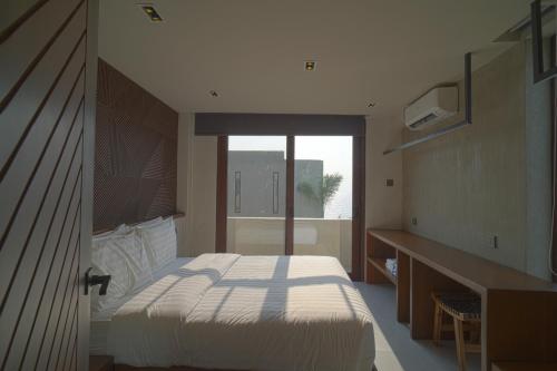 a bedroom with a bed and a desk and a window at Araya Beach Casas in Batangas City