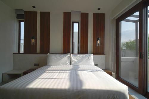 a large bed in a room with a large window at Araya Beach Casas in Batangas City