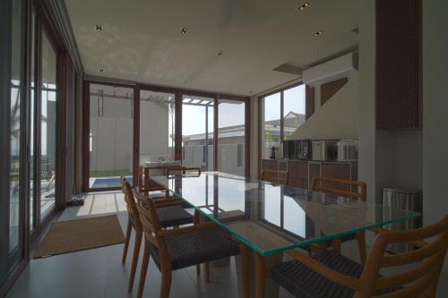 a dining room with a glass table and chairs at Araya Beach Casas in Batangas City