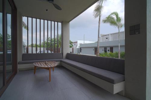 a balcony with a bench and a table and palm trees at Araya Beach Casas in Batangas City