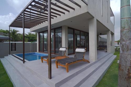 a house with two chairs and a pool at Araya Beach Casas in Batangas City