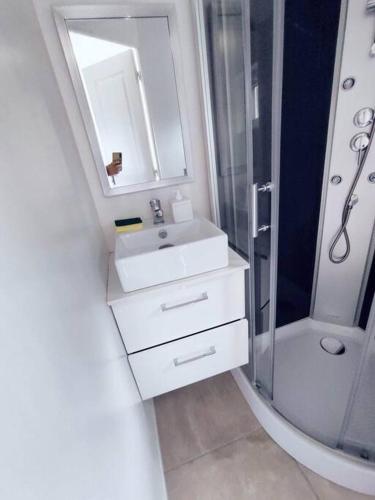 une salle de bain blanche avec un lavabo et une douche dans l'établissement R10 Idéal déplacement pro, à Cambrai
