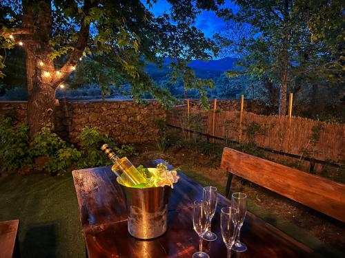 un tavolo con bicchieri da vino e un secchio sopra di Casa rural Paraje de Yuste a Cuacos de Yuste
