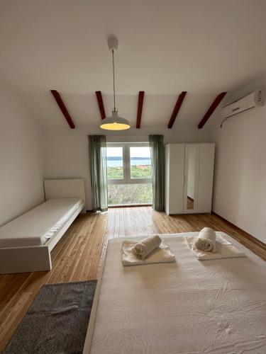 a large room with two beds and a large window at Matisse Residence in Nerezine